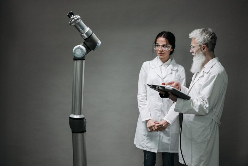 Zwei Forschende begutachten einen kollaborativen Roboterarm